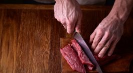 Un homme coupe un morceau de viande