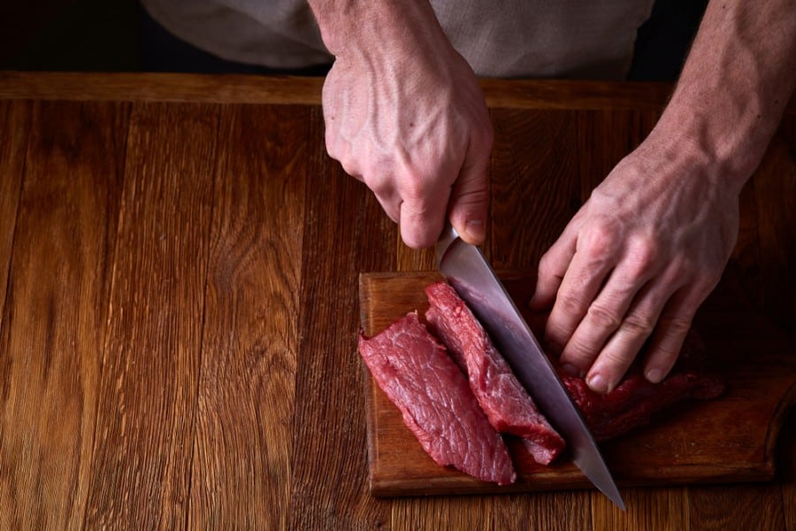 Un homme coupe un morceau de viande