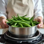 Femme déposant des haricots verts dans le panier vapeur d'une cocotte-minute sur un plan de travail de cuisine moderne